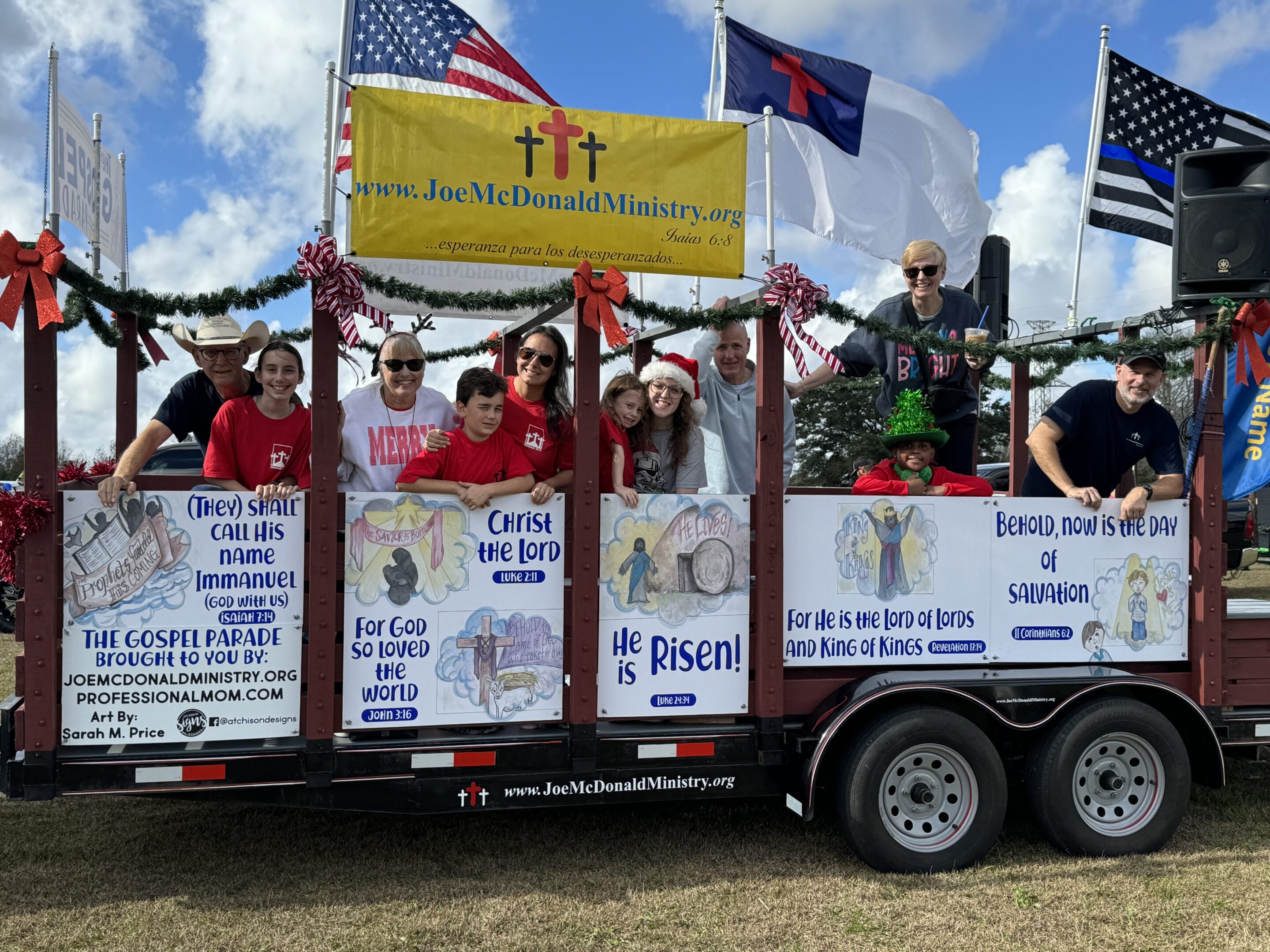 IMG_0285 People on a decorated trailer holding signs and flags during a parade.