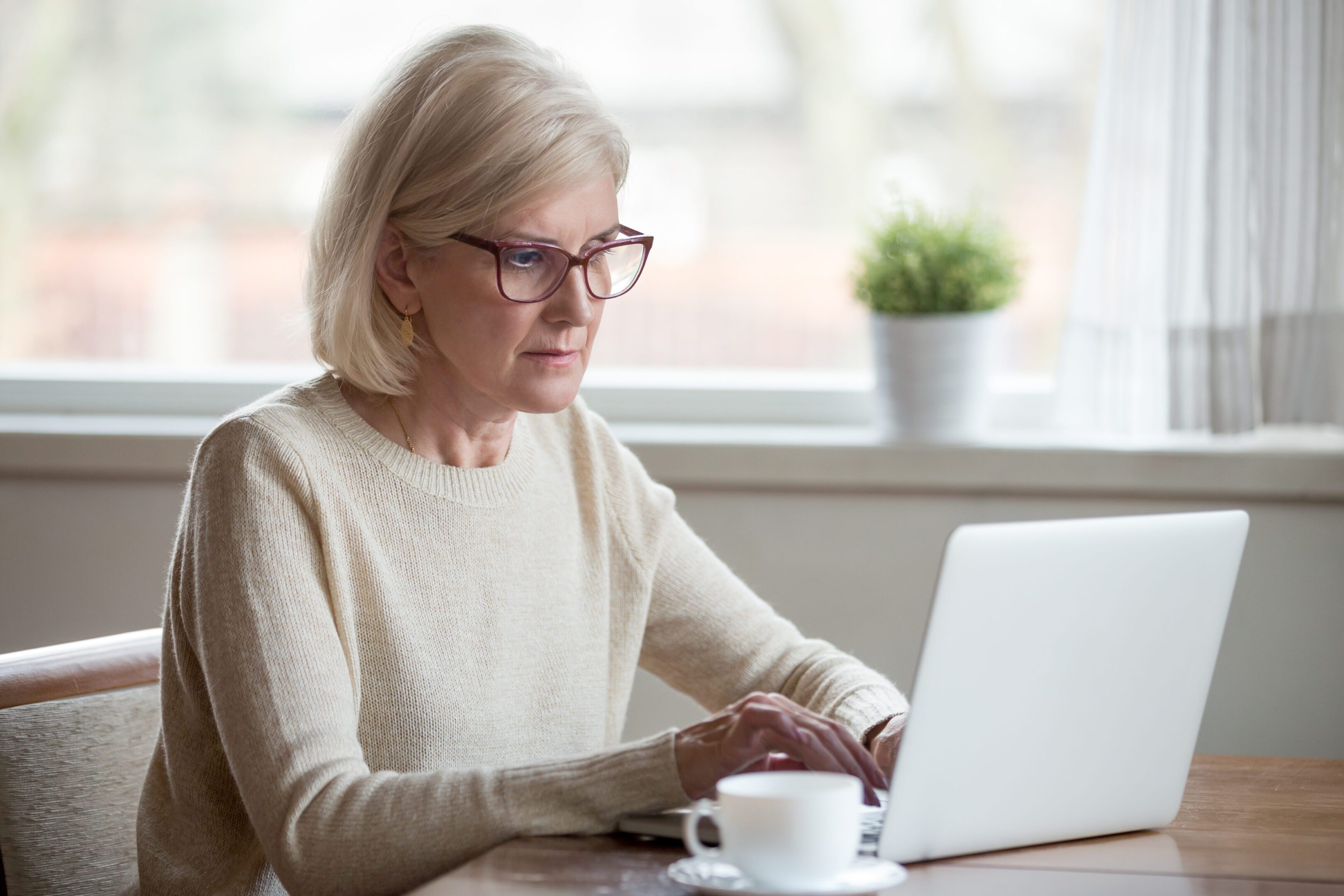 Older woman working on a laptop.